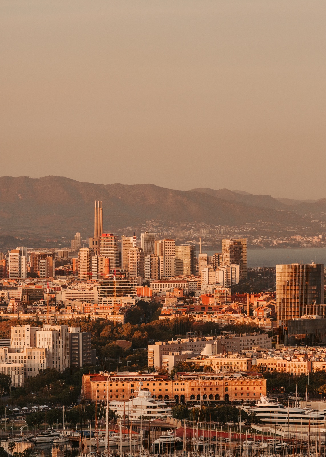 The city’s towers above the marina in warm light, with the hills beyond