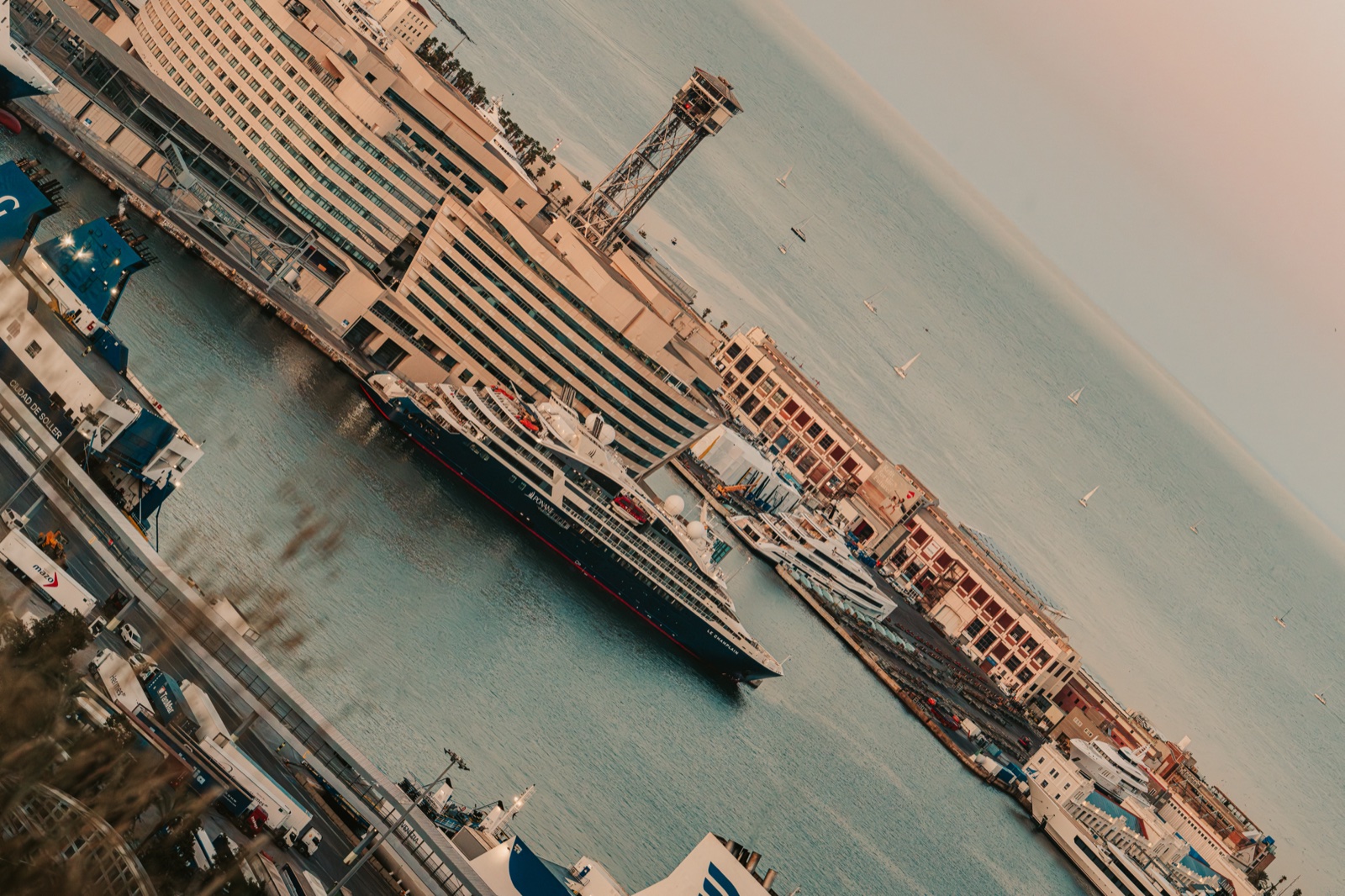 Cruise ships moored in the port beside a cable car tower, seen at a tilt