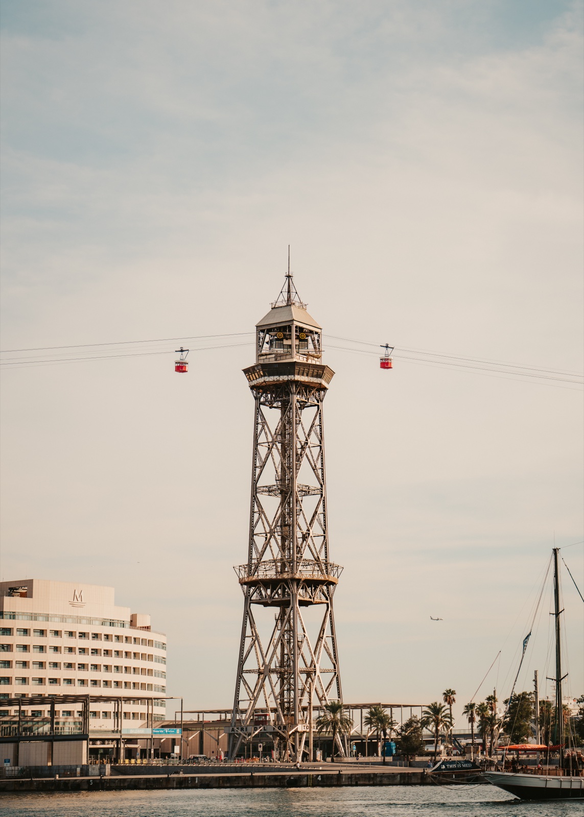 The cable car tower at the port, with two red cabins on the wires